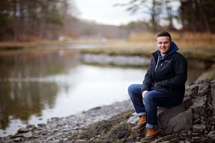 Man sitting on rocks by a lake