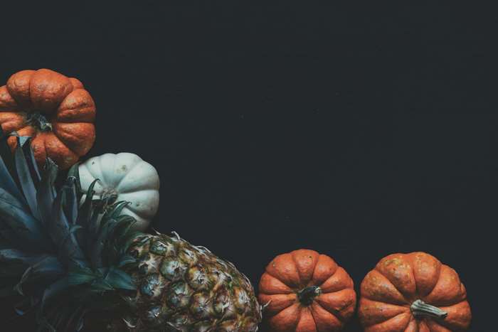 Pineapple and pumpkins on a black background