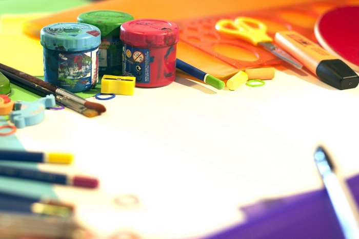 Art supplies including paint jars, brushes, and scissors
