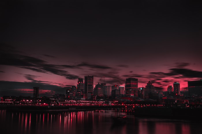 City skyline at night with red lights and reflections