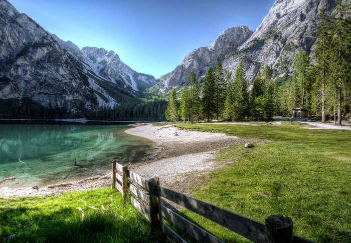 Mountain lake landscape with trees and fence