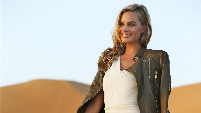 Smiling Margot Robbie in White Dress and Leather Jacket