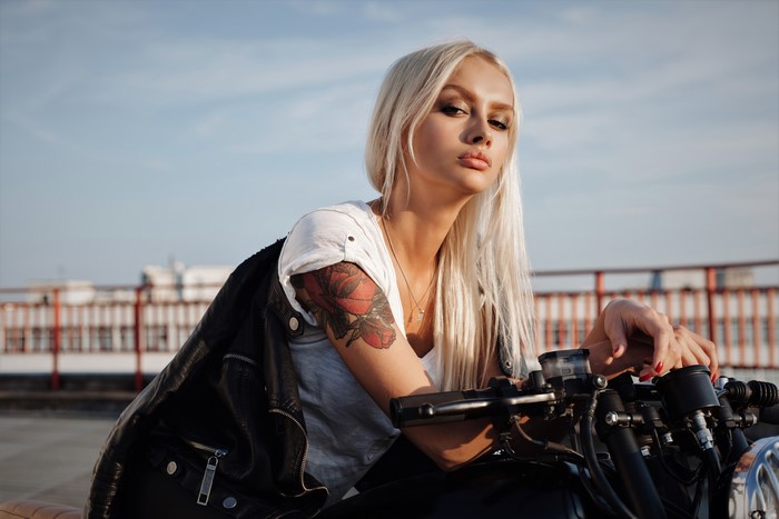 Blonde woman with tattoo on motorcycle