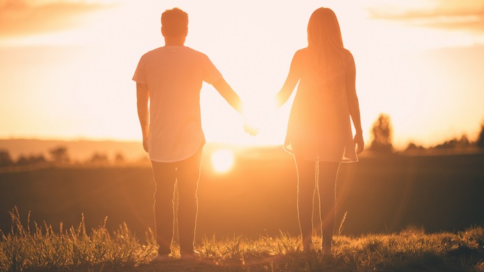 Couple holding hands at sunset