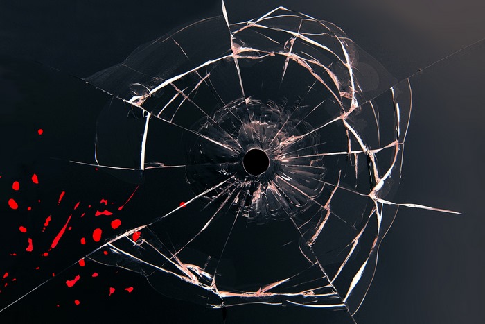 Broken glass with bullet hole and blood splatters