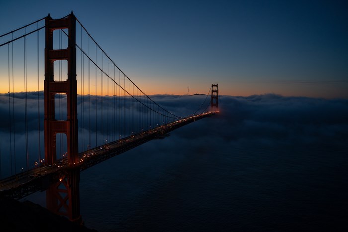 Golden Gate Bridge shrouded in fog at dusk