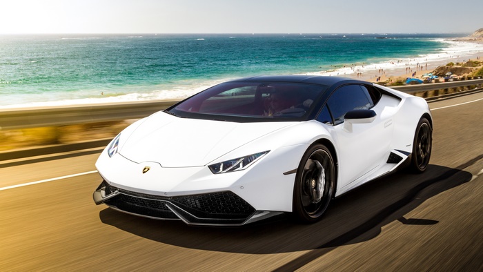 White Lamborghini Huracan driving on coastal road