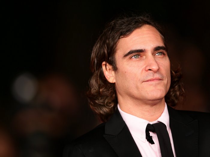 Joaquin Phoenix with long hair and green eyes