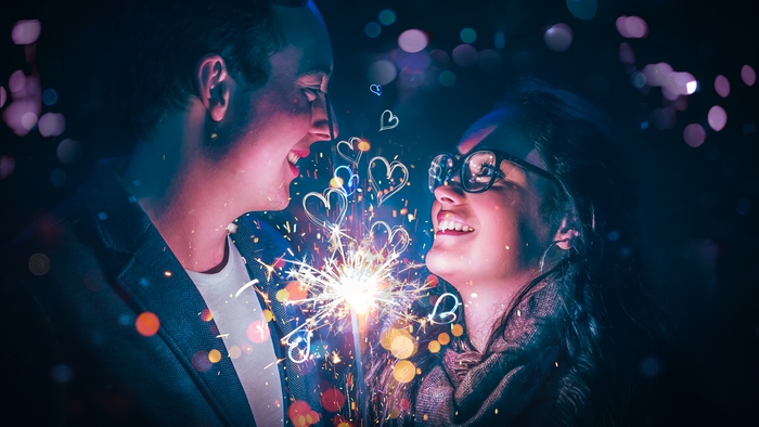 Couple holding sparklers with hearts