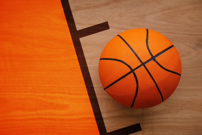 Basketball on a wooden court with orange markings