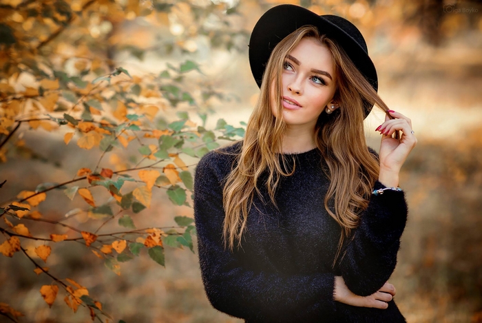 Blonde Woman in Black Hat Among Autumn Leaves