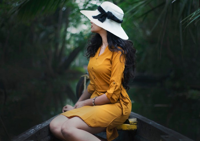 Woman in yellow dress and hat on a boat