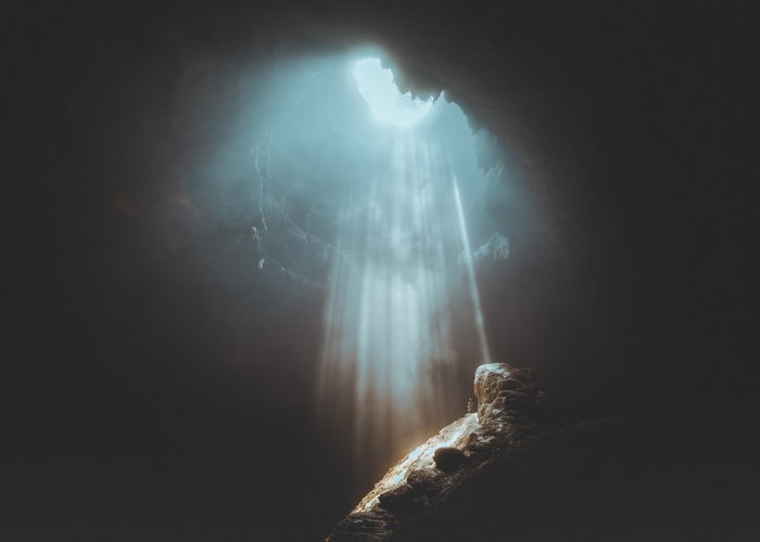 Sunlight beams into a dark cave in Indonesia