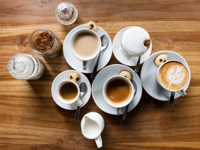 Coffee cups with cookies and sugar on a wooden table