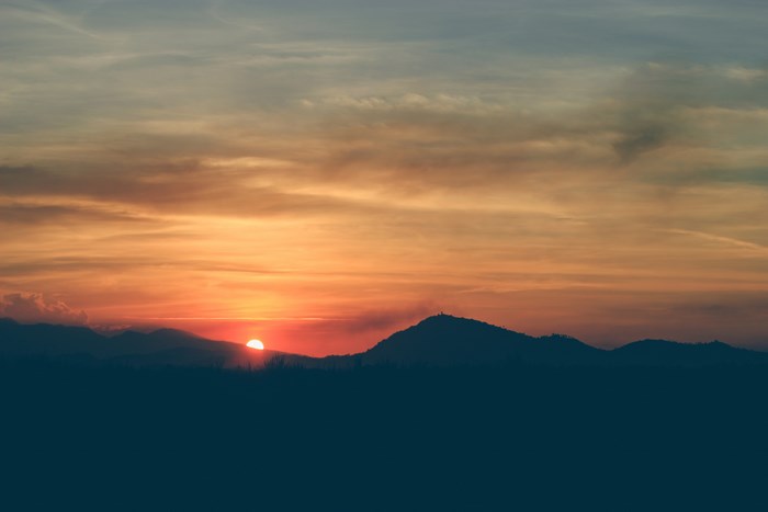 Sunset over mountains with orange clouds