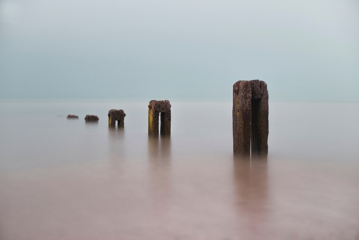 Wooden posts in the sea with long exposure