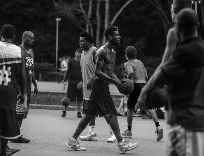 Men playing basketball on an outdoor court
