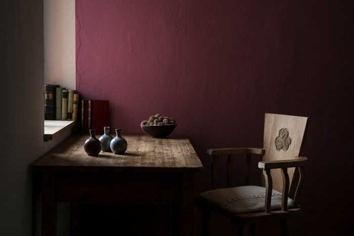 Wooden desk with books, vases, and a bowl of gourds