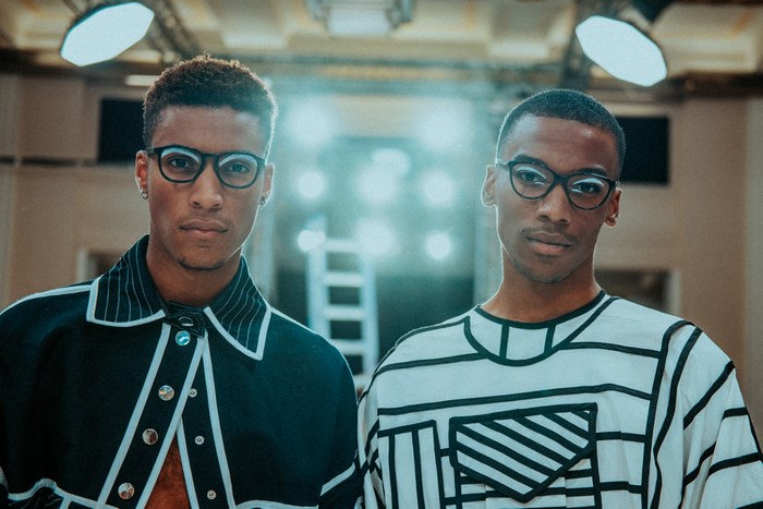 Two African American men wearing glasses and fashionable clothing
