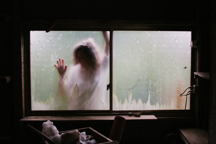 Woman trapped behind a frosted window