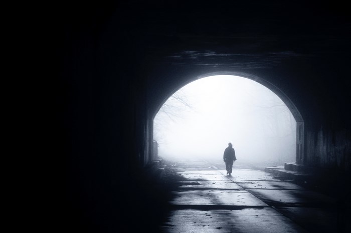 Person walking through a foggy tunnel