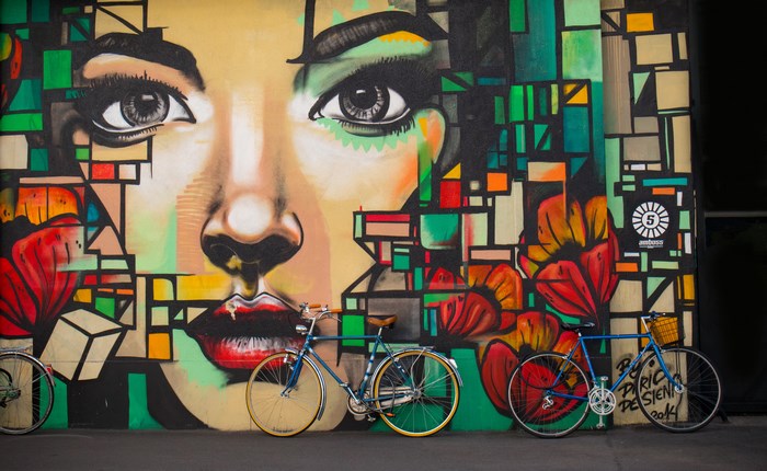 Graffiti mural of a woman's face with bicycles