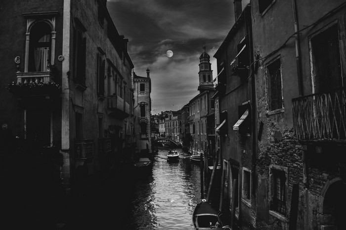 Venice canal at night with moon and boat