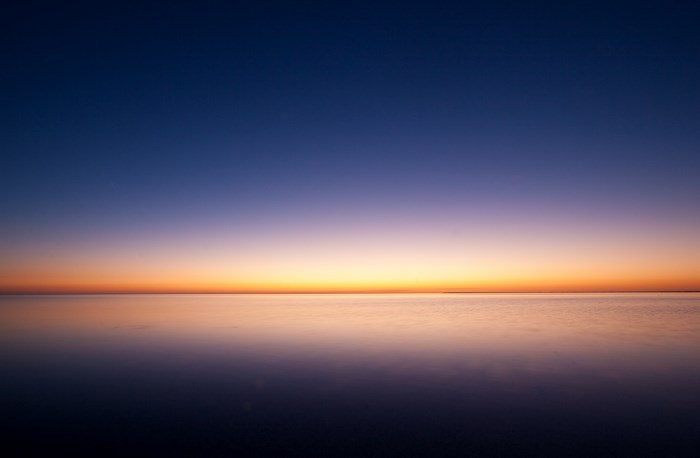 Calm ocean horizon at dawn with gradient sky