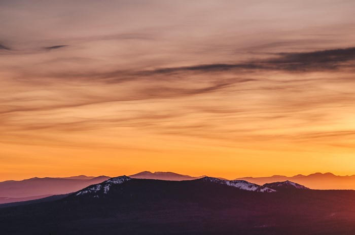 Mountain range at sunset with orange sky