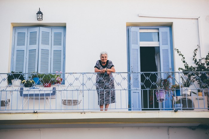 Elderly woman on a balcony in Greece