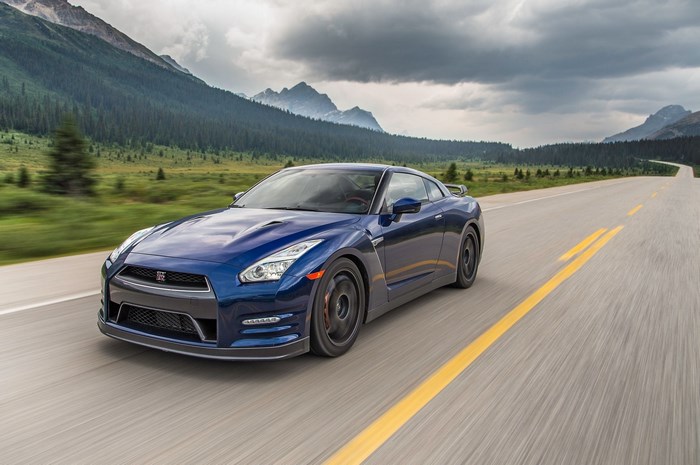 Blue Nissan GT-R driving on a mountain road