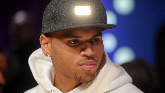 Chris Brown wearing a baseball cap and hoodie