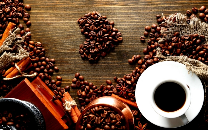 Coffee beans, cinnamon sticks, and a cup of coffee
