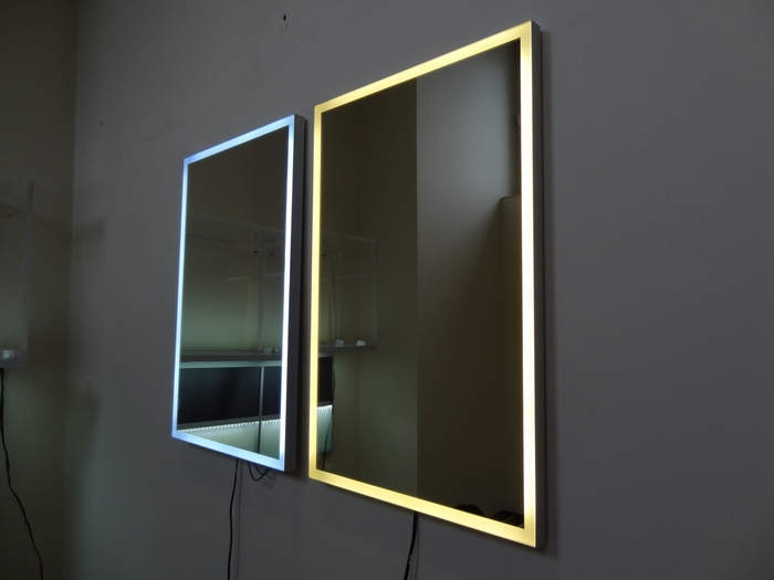 Two illuminated mirrors on a wall