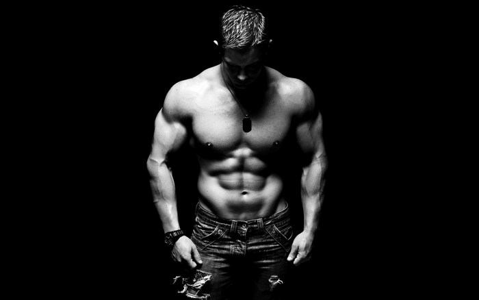 Muscular man with ripped jeans and dog tag necklace