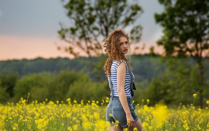 Young woman in a field of yellow flowers