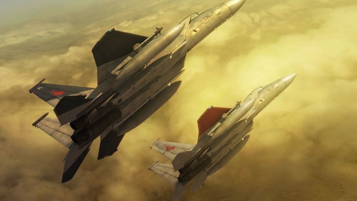 Two fighter jets flying through clouds