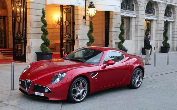 Red Alfa Romeo 8C Competizione parked outside a building