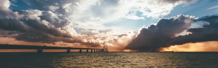 Bridge over water with dramatic clouds