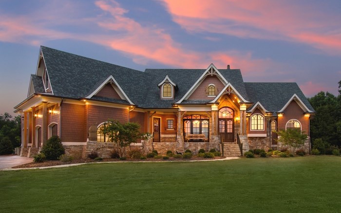 Luxury mansion with stone and wood exterior at dusk