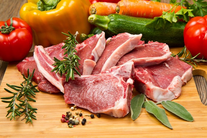 Raw lamb chops with vegetables and herbs