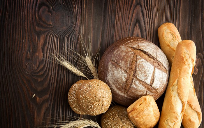 Assortment of bread and wheat on a wooden table