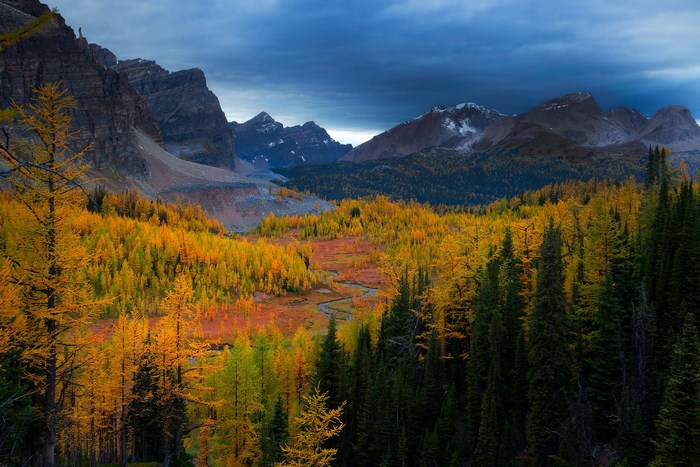 Autumn valley with mountains and dark clouds