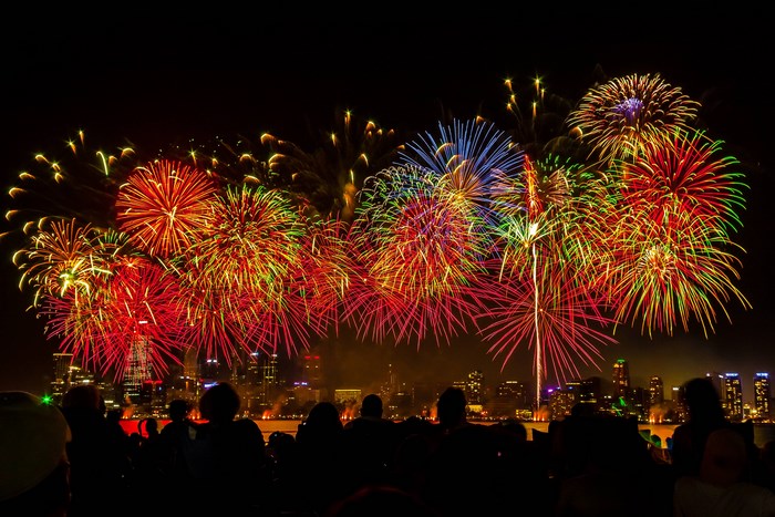 Fireworks display over a city skyline at night