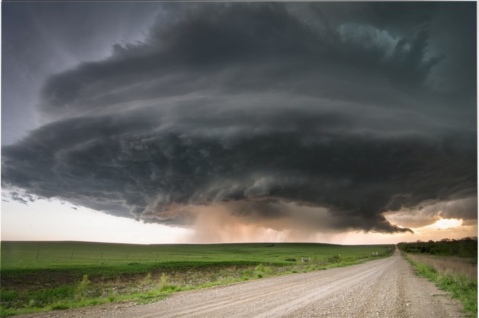 Storm clouds over a rural landscape with a dirt road