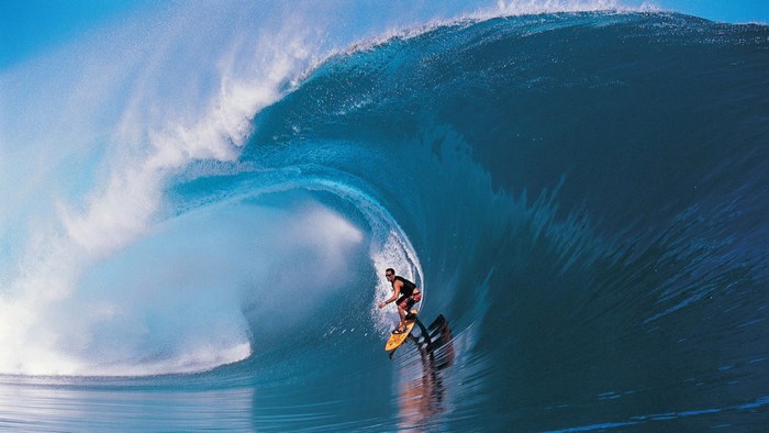 Surfer riding a massive wave tube
