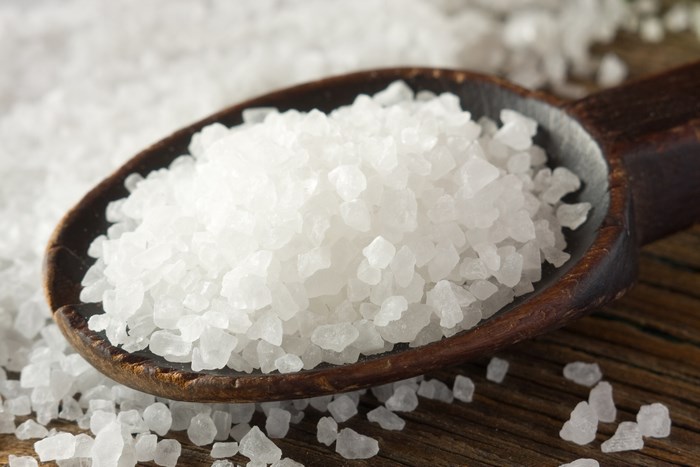Coarse sea salt on a wooden spoon