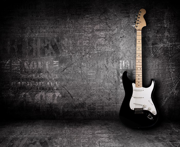 Black electric guitar on a grunge wall