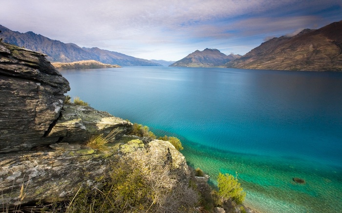 Turquoise lake surrounded by mountains and rocky shore