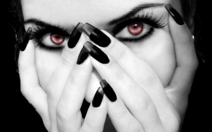 Gothic woman with red eyes and black nails